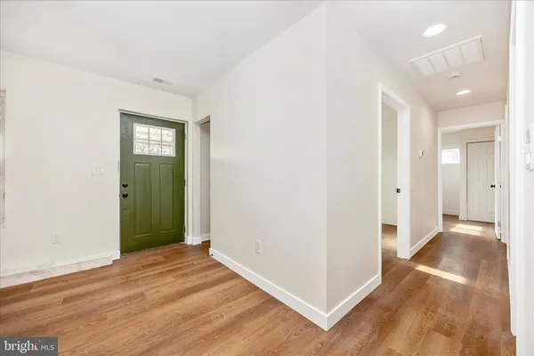 a view of a hallway with wooden floor and closet area