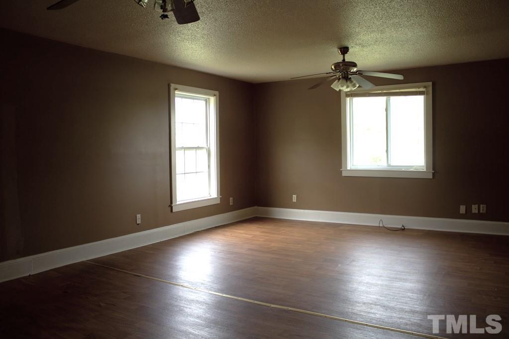 9592 Kennebec Road Willow Spring, NC 27592 - Photo 8 of 14 an empty room with wooden floor and windows