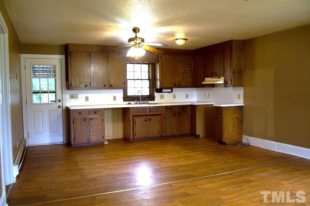 9592 Kennebec Road Willow Spring, NC 27592 - Photo 9 of 14 a kitchen with a sink cabinets and wooden floor