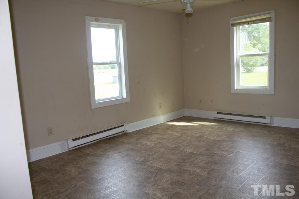 9592 Kennebec Road Willow Spring, NC 27592 - Photo 10 of 14 an empty room with wooden floor and windows