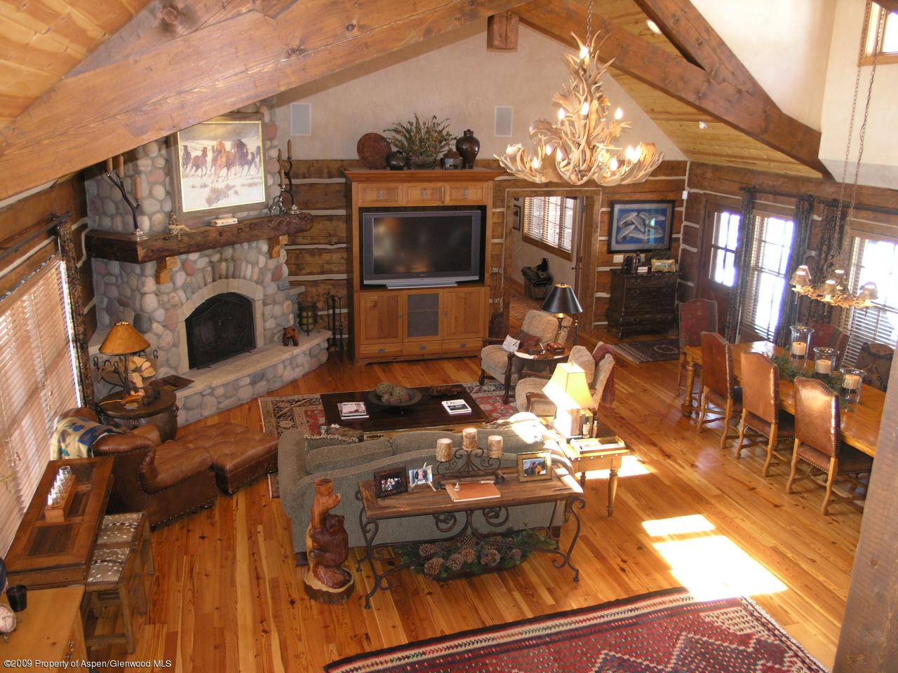 200 Altamira Ranch Road Basalt, CO 81621 - Photo 8 of 26 a living room with furniture a fireplace and a chandelier