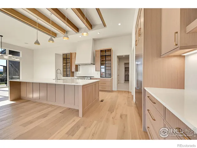 a kitchen with kitchen island granite countertop a sink cabinets and wooden floor