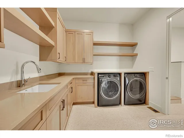 a utility room with sink dryer and washer