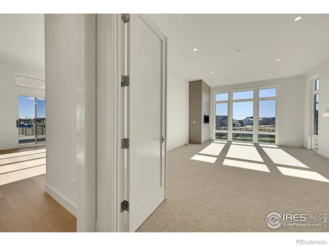 a living room with furniture a large window with kitchen view