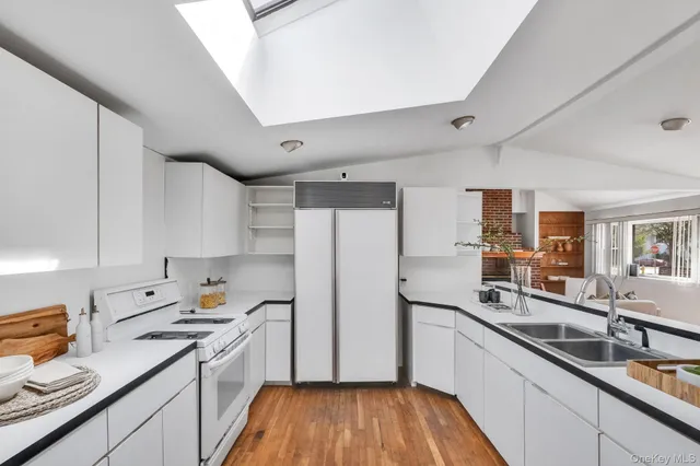 a kitchen with stainless steel appliances a sink cabinets and wooden floor