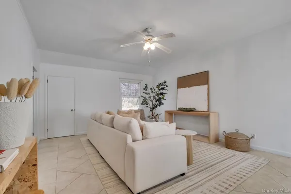 a living room with furniture and a ceiling fan