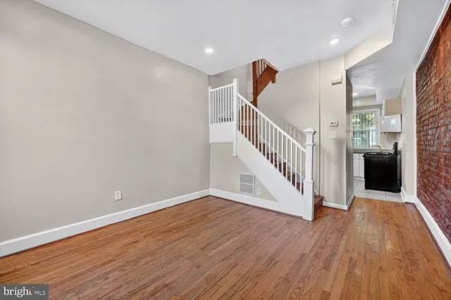 a view of a hallway with wooden floor and staircase