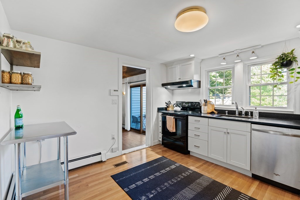 3 Castle Avenue Medfield, MA 02052 - Photo 6 of 36 a kitchen with granite countertop a stove and white cabinets