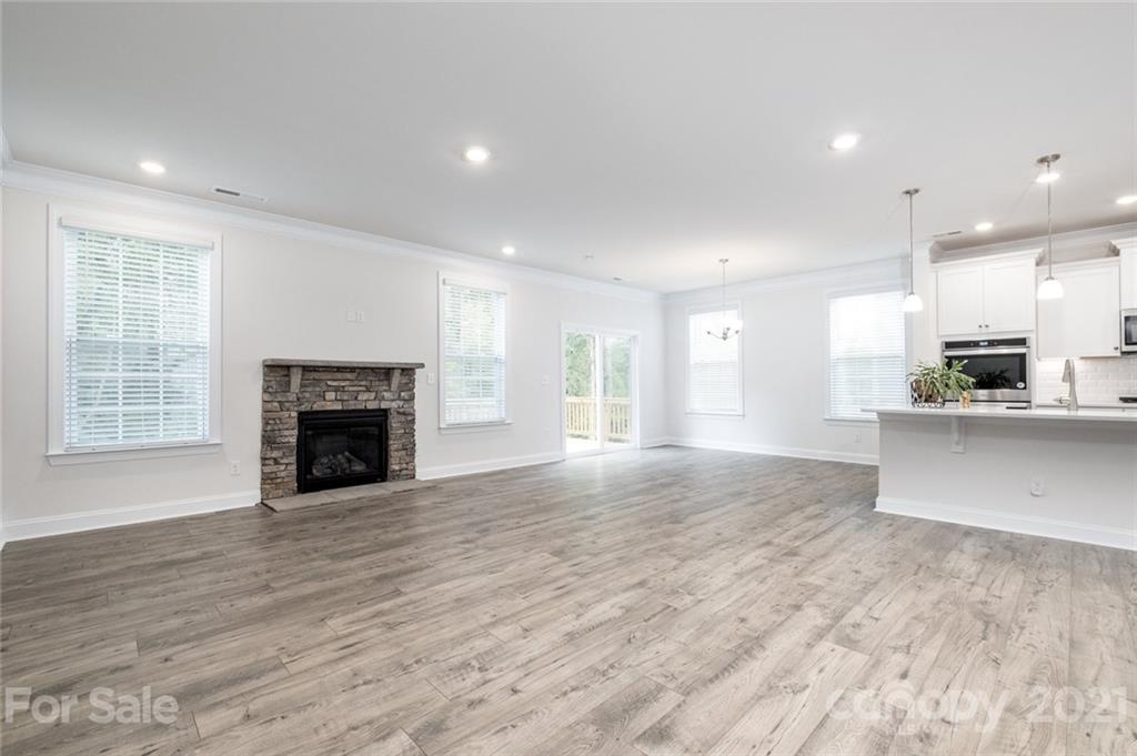 420 Preston Road Mooresville, NC 28117 - Photo 12 of 39 a view of an empty room with wooden floor and a kitchen