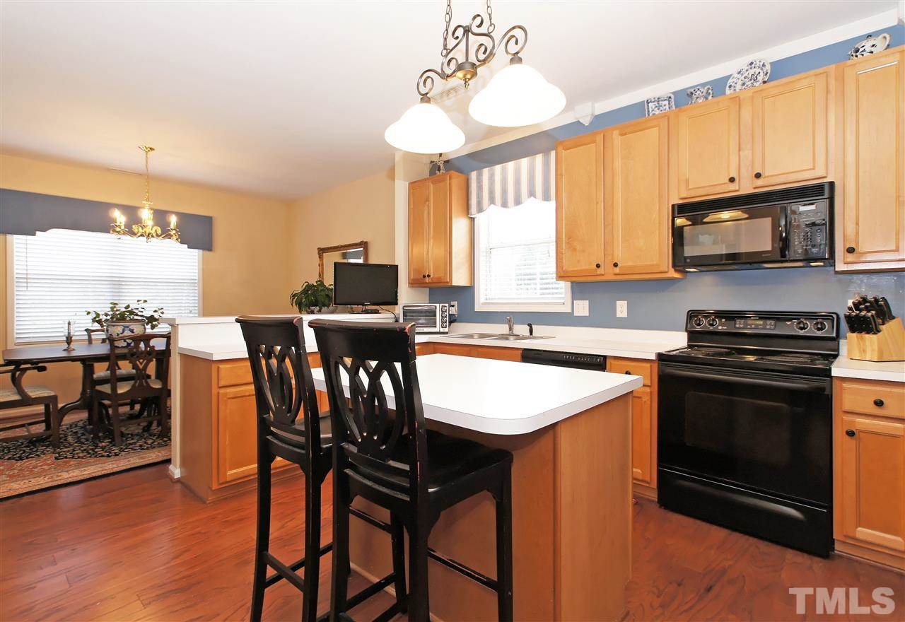 113 Inkster Cove Raleigh, NC 27603 - Photo 9 of 24 a kitchen with stainless steel appliances granite countertop a stove a sink a microwave and a refrigerator