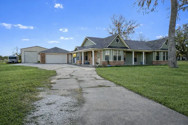 a front view of a house with a garden and yard