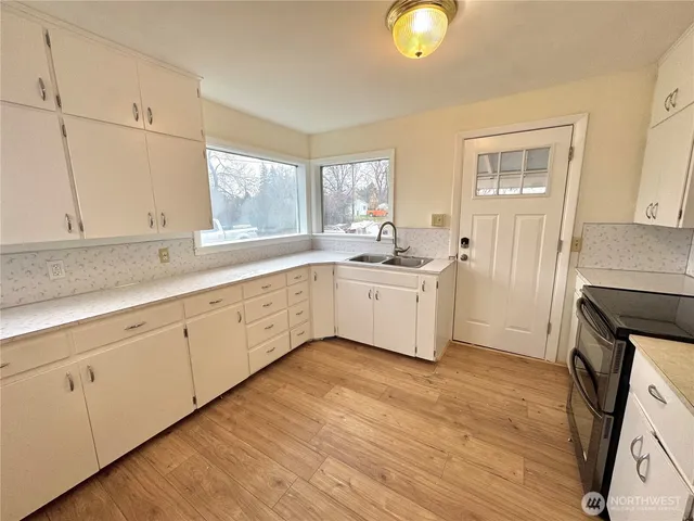 a large white kitchen with sink and window