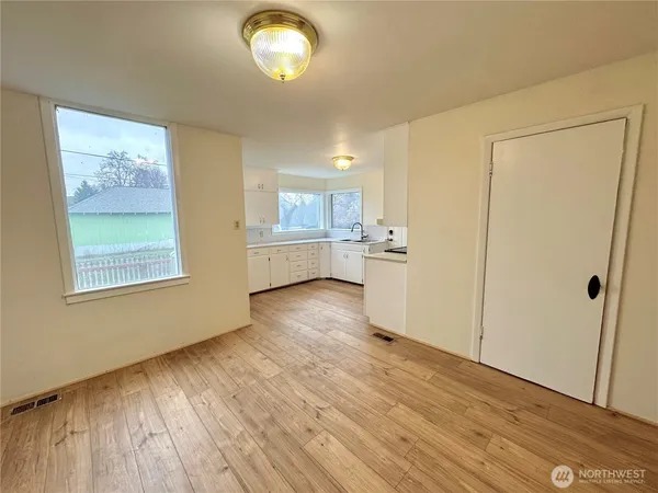 a view of empty room with wooden floor and window