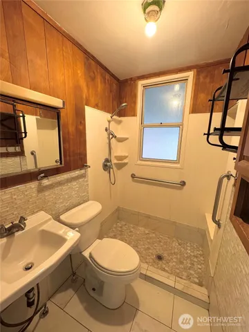 a bathroom with a sink a toilet and shower