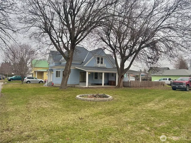 a front view of a house with yard and trees