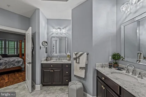 a en suite bathroom with a granite countertop sink and a mirror