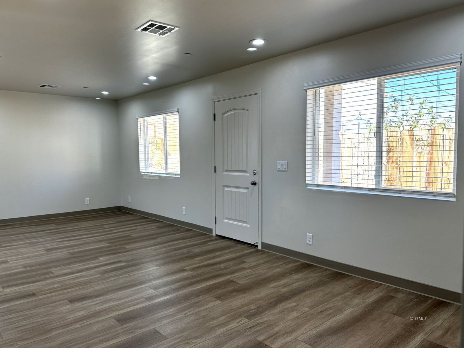 1424 South Farragut Street Ridgecrest, CA 93555 - Photo 3 of 13 a view of an empty room with wooden floor and a window