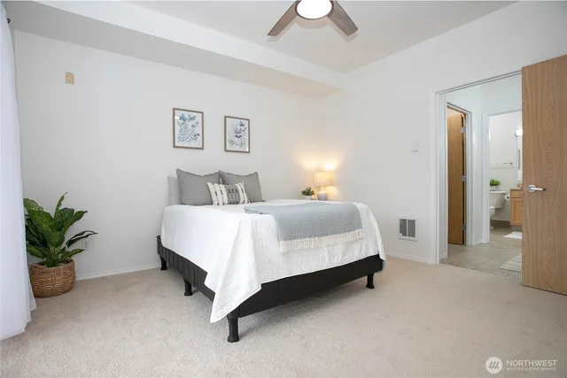 a spacious bedroom with a bed and a potted plant