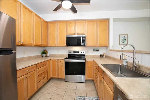 a kitchen with stainless steel appliances granite countertop a stove sink and cabinets