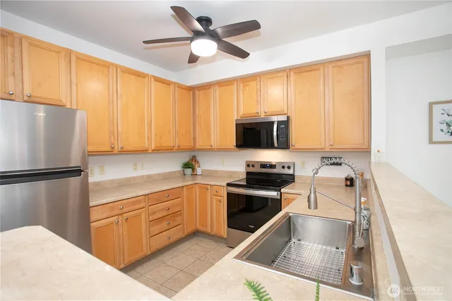 a kitchen with a refrigerator sink and cabinets