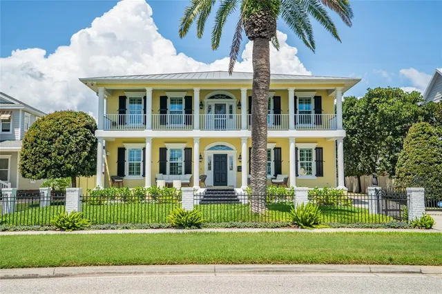 a front view of a residential apartment building with a yard and potted plants