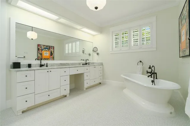 a kitchen with stainless steel appliances granite countertop white cabinets a sink a stove a refrigerator and microwave with wooden floor