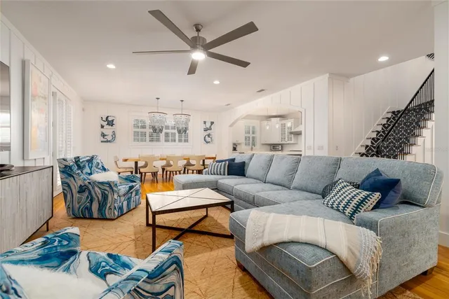 a kitchen with stainless steel appliances granite countertop a sink a stove a refrigerator and island with wooden floor