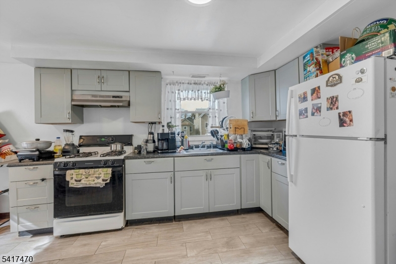 13 Allen Street Passaic, NJ 07055 - Photo 2 of 7 a kitchen with a white cabinets and white appliances