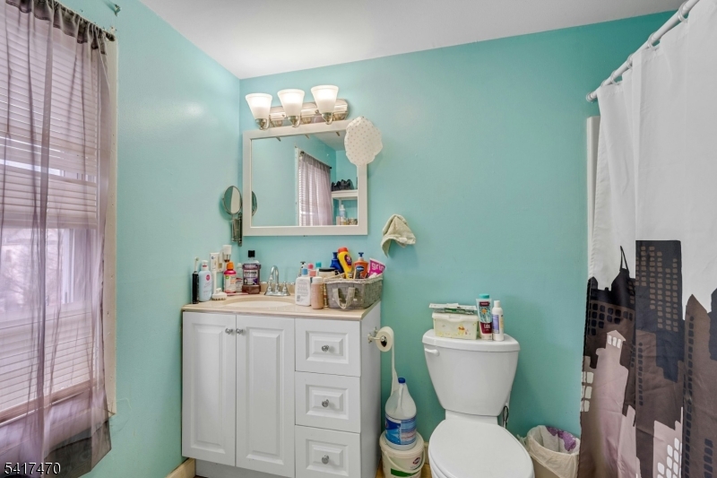 13 Allen Street Passaic, NJ 07055 - Photo 6 of 7 a bathroom with a toilet sink vanity and mirror