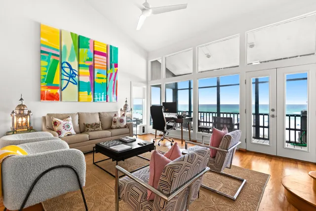 a living room with furniture kitchen view and large windows
