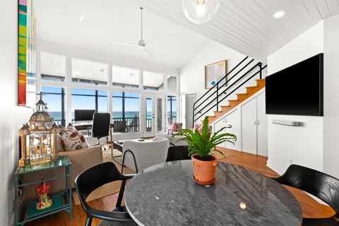 a dining room with furniture potted plants and wooden floor