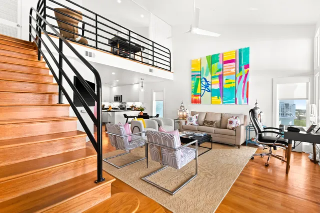 a living room with furniture and stairs with wooden floor