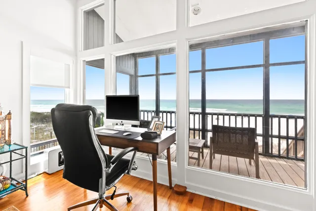 a view of a workspace with furniture and a window