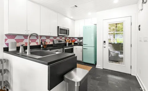 a kitchen with stainless steel appliances granite countertop a sink and a refrigerator
