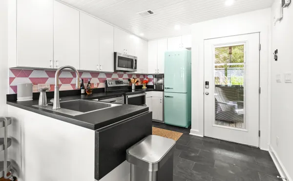 a kitchen with stainless steel appliances granite countertop a sink and a refrigerator