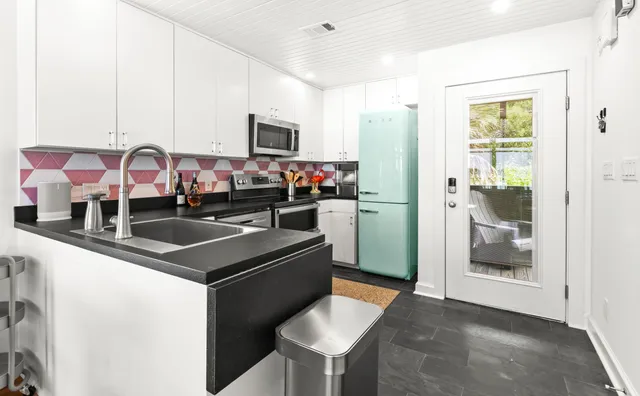 a kitchen with stainless steel appliances granite countertop a sink and a refrigerator