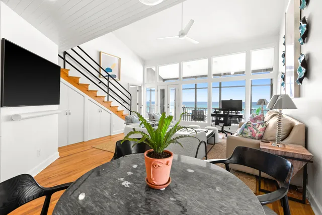 a dining room with furniture and a potted plant
