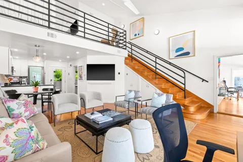 a living room with furniture kitchen view and a flat screen tv