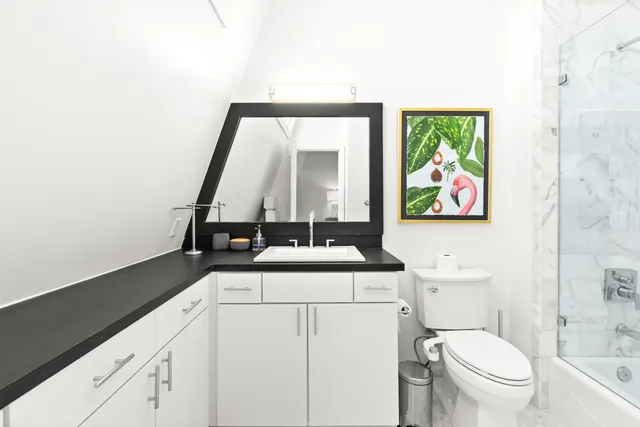 a view of bathroom with a toilet sink and mirror