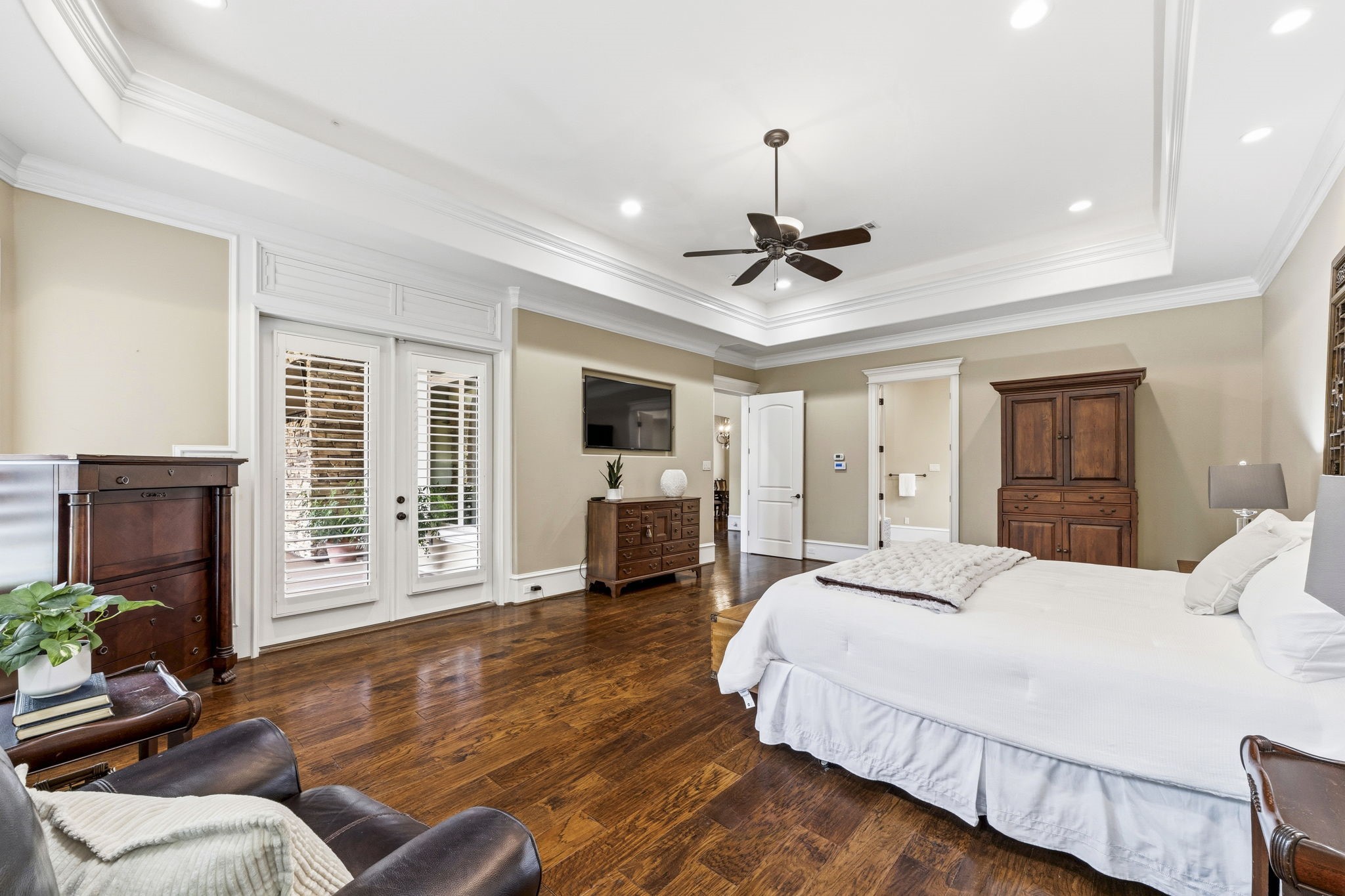 27402 Jacob's Path Lane Spring, TX 77386 - Photo 25 of 48 he primary bedroom beautifully continues the exceptional craftsmanship and architectural details found throughout the home. Generously sized, this elegant retreat offers ample space for furnishings and comfortable living—be sure to note the room dimensions in the listing. A tray ceiling adds sophistication, while direct access to the back veranda creates a seamless connection to the outdoor living spaces, making it easy to enjoy peaceful mornings and relaxing evenings.