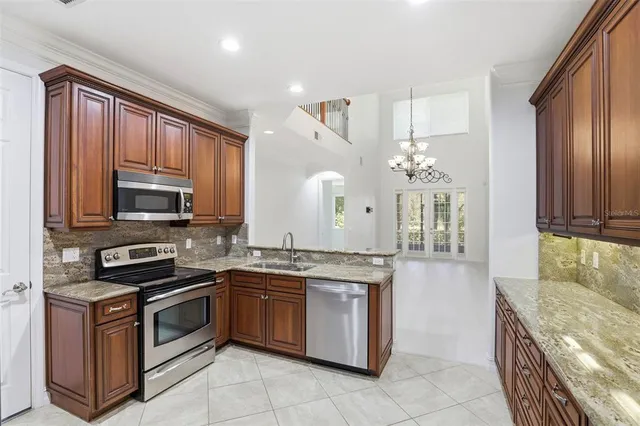 a kitchen with stainless steel appliances granite countertop a refrigerator stove and cabinets