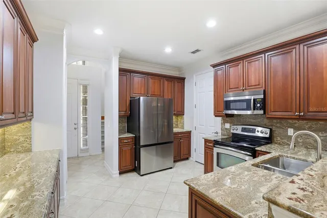 a kitchen with stainless steel appliances granite countertop a refrigerator and a stove top oven