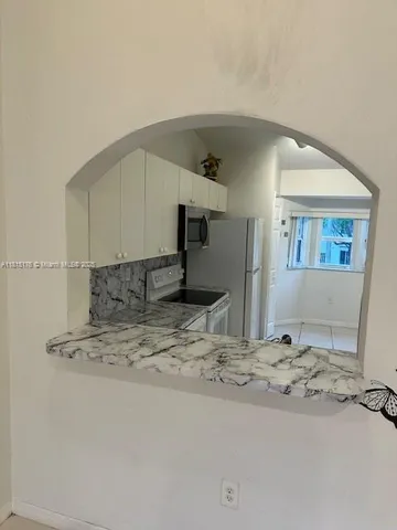 a kitchen with cabinets a refrigerator and a stove