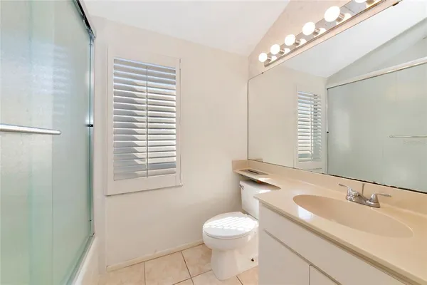 a bathroom with a sink a toilet a mirror and a window
