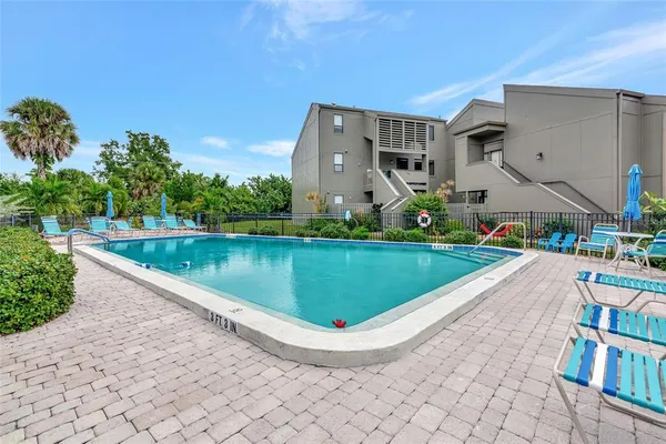 a view of a swimming pool with a yard and sitting space