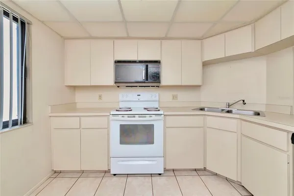 a kitchen with cabinets appliances a sink and a counter top space