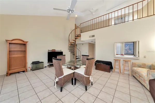 a living room with couches chairs and kitchen view with wooden floor