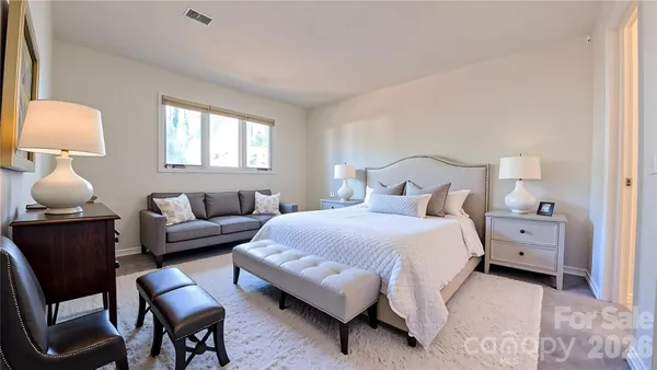 a bedroom with bed and window with chair