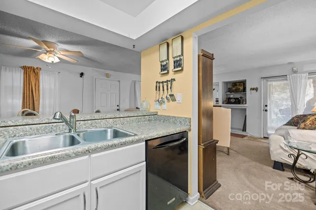 a kitchen with granite countertop a sink and refrigerator
