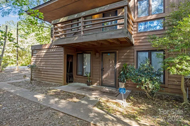 a view of a house with a yard and potted plants
